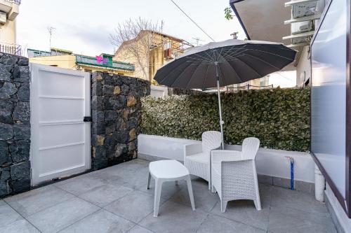 a table and chairs with an umbrella on a patio at Belsito Suite in Misterbianco
