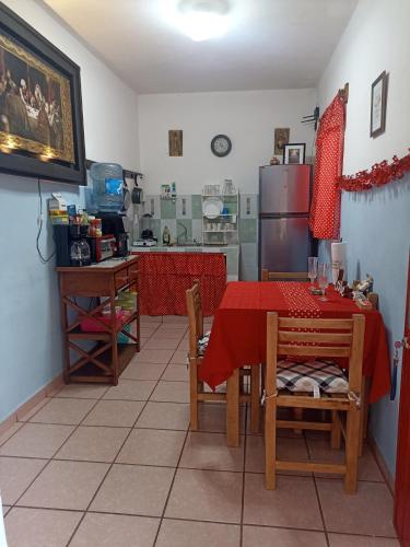 a kitchen with a red table and a refrigerator at Casa Chero in Comalcalco