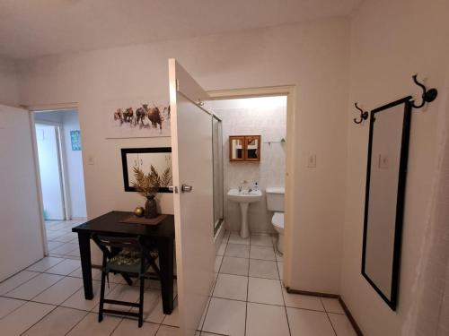 a bathroom with a sink and a toilet and a table at Ocean Tides - 2 Adults & 4 Kids ONLY in Umdloti