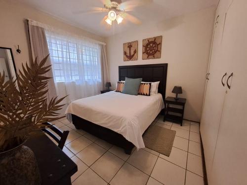 a bedroom with a bed and a plant in it at Ocean Tides - 2 Adults & 4 Kids ONLY in Umdloti