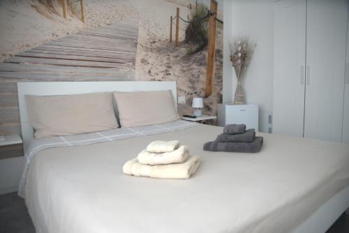 a bedroom with a white bed with towels on it at b&b Casa Balai 72 a 100 mt dal mare in Porto Torres