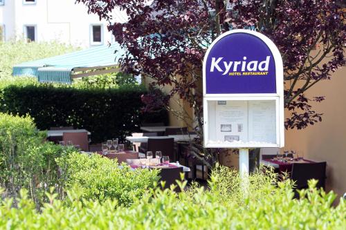 a sign sitting in the grass next to some tables at Kyriad Nancy Sud - Ludres in Ludres