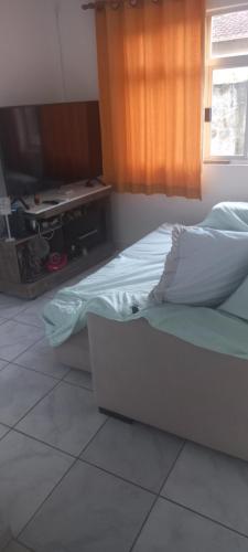 een ongemaakt bed in een kamer met een raam bij Espaço tranquilo in Florianópolis