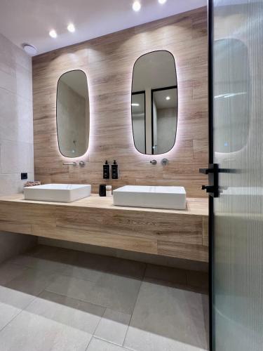 a bathroom with two sinks and two mirrors at Anaxo Resort in Riglia
