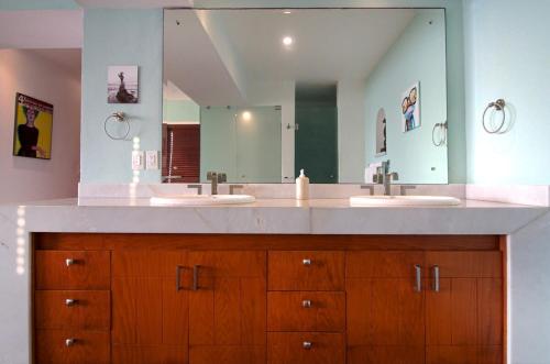 Un baño con dos lavabos y un espejo grande. en Modern Beachfront - Casa Caballito del Mar, en Puerto Vallarta