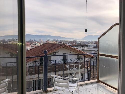 a balcony with two chairs and a view of a city at Ion Apartments Messolonghi Single Bed Room Mountain View Loft in Mesolongion
