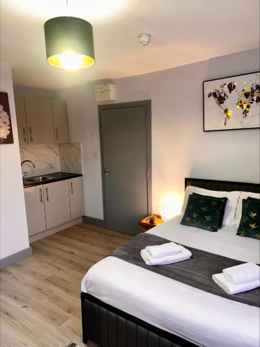 a bedroom with a large bed and a kitchen at The Wolfs Tavern in London