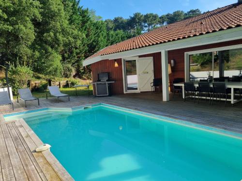 - une piscine en face d'une maison avec une terrasse dans l'établissement Villa Marylou, à Seignosse