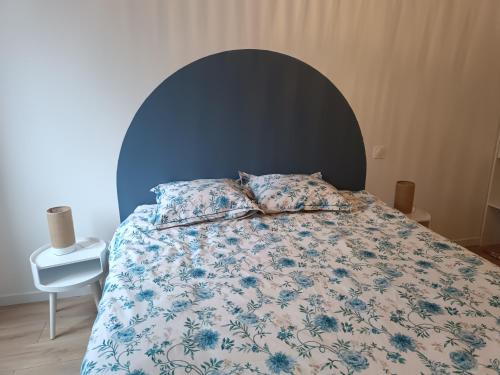 a bedroom with a bed with a blue head board at Appartement moderne et bohème in Vittel