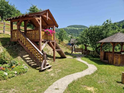 a wooden playground in a garden with a gazebo at Садиба "Ековид" in Krivorovnya