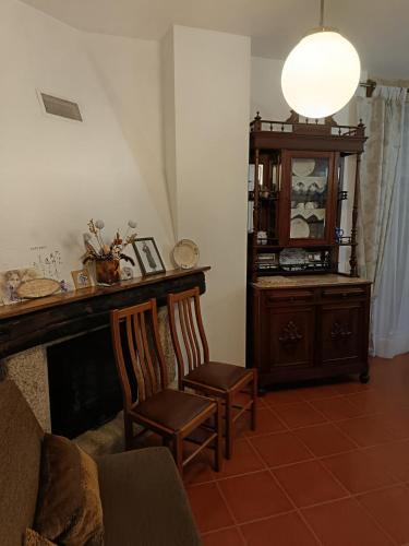 a living room with a fireplace and a chair at Casa Pires Mateus in Monsanto