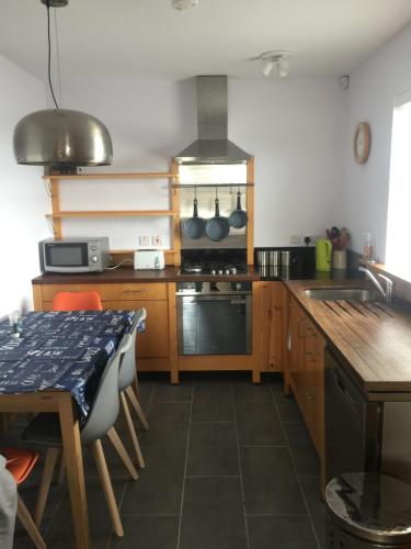 a kitchen with wooden cabinets and a table with a tableablish at Harbour Cottage Ballintoy in Ballintoy