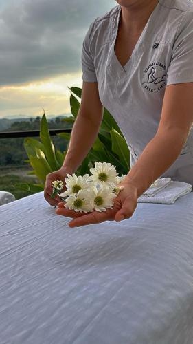 a woman holding a bunch of flowers on a table at cabaña mulata in La Tebaida