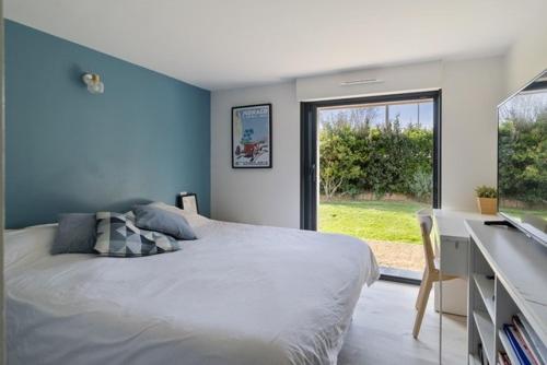 a bedroom with a bed and a desk and a window at Beautiful new ocean facing villa in Anglet