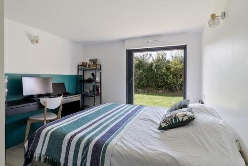 a bedroom with a bed and a desk and a window at Beautiful new ocean facing villa in Anglet