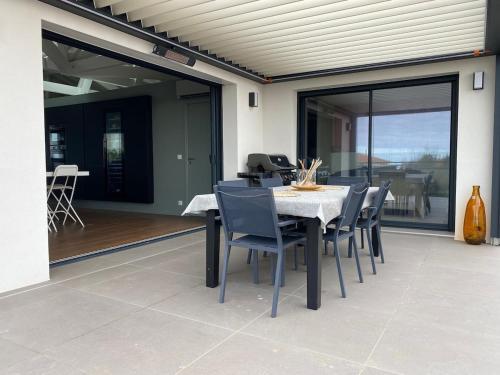 a dining table and chairs on a patio at Beautiful new ocean facing villa in Anglet