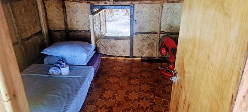 a small room with a bed and a window at ocamocam cottages in Ocam Ocam
