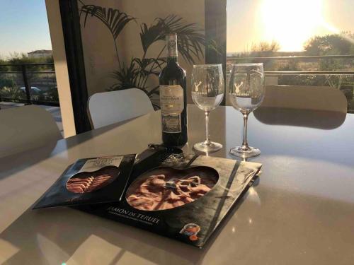 a bottle of wine and two glasses on a table at Beautiful new ocean facing villa in Anglet