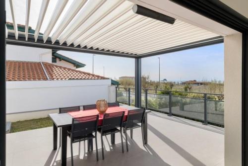 a patio with a table and chairs on a balcony at Beautiful new ocean facing villa in Anglet