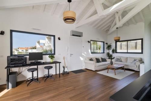a living room with a desk with a computer in it at Beautiful new ocean facing villa in Anglet