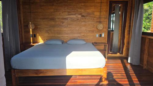 a bedroom with a bed in a wooden room at bacalar My Love Front Laguna in Bacalar