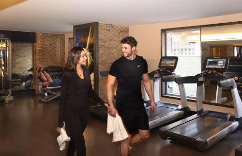 a man and a woman walking on treadles in a gym at InterContinental New York Times Square by IHG in New York