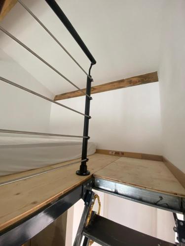 a stairwell in a room with wood and metal railings at nouvelle appartement T2 mezzanine et piscine in Valergues