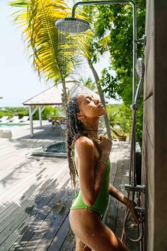 a statue of a woman in a green bathing suit drinking water at All-Inclusive Experience at Villa Azur in Les Terres Basses
