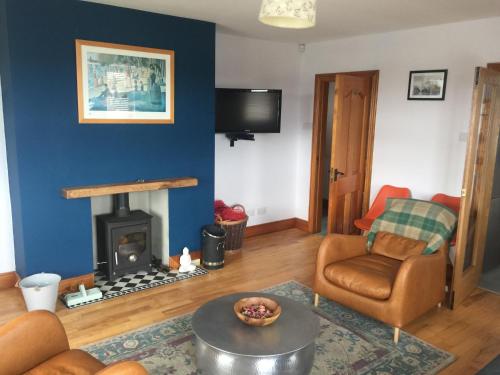 a living room with a couch and a fireplace at Harbour Cottage Ballintoy in Ballintoy
