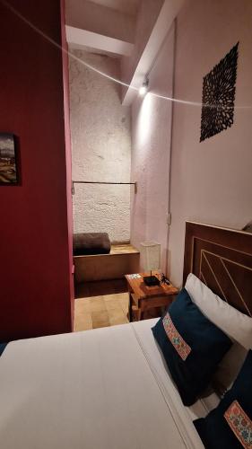 a bedroom with a bed and a couch in a room at Posada La Plazuela in Cuetzalán del Progreso