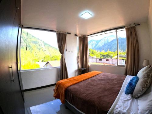 ein Schlafzimmer mit einem Bett und einem großen Fenster in der Unterkunft CASA VISTA HERMOSA in Baños