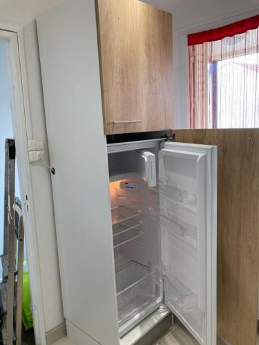 un réfrigérateur vide avec sa porte ouverte dans une cuisine dans l'établissement Superbe Chambre ParentaleDouche Privée et WC Privés, Wifi, Cuisine Intégrée, à Vandœuvre-lès-Nancy