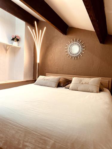 - une chambre avec un grand lit blanc et une lumière dans l'établissement T2 mezzanine avec loggia vue montagne au Port de Saint-Cyprien, à Saint Cyprien Plage