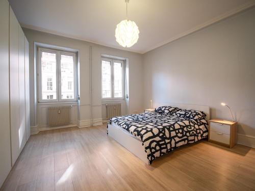 une chambre avec un lit et deux fenêtres dans l'établissement Strasbourg à vos pieds, appartement moderne et lumineux, à Strasbourg