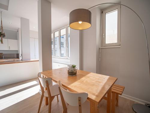 une cuisine et une salle à manger avec une table et des chaises en bois dans l'établissement Strasbourg à vos pieds, appartement moderne et lumineux, à Strasbourg