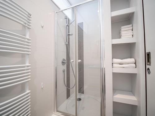 La salle de bains est pourvue d'une douche en verre et de serviettes blanches. dans l'établissement Strasbourg à vos pieds, appartement moderne et lumineux, à Strasbourg