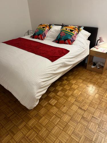 - un lit avec des draps blancs et des oreillers colorés dans l'établissement Appt entier MONPARNASSE avec TERRASSE et PARKING, à Paris