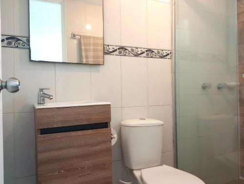 une salle de bain avec toilettes, lavabo et miroir dans l'établissement Beautiful oasis of peace in the heart of Pradomar!, à Puerto Colombia
