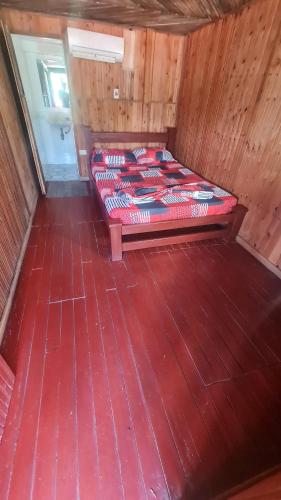 a bed in a room with a wooden floor at bahia del sol - ladrilleros in Buenaventura
