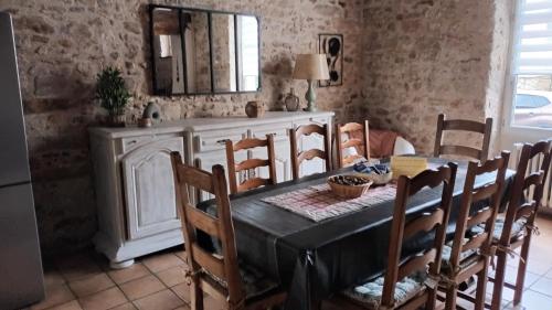 a dining room with a table and chairs and a mirror at La Manounière in Mauchamps
