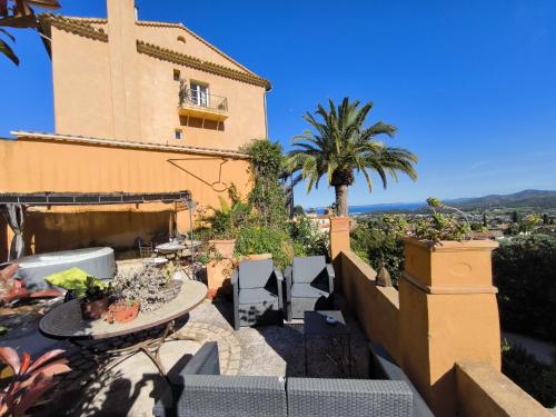 un patio avec une table et des chaises et un bâtiment dans l'établissement Love-room Discret 40 m2 Bormes les mimosas village avec Terrasse, à Bormes-les-Mimosas