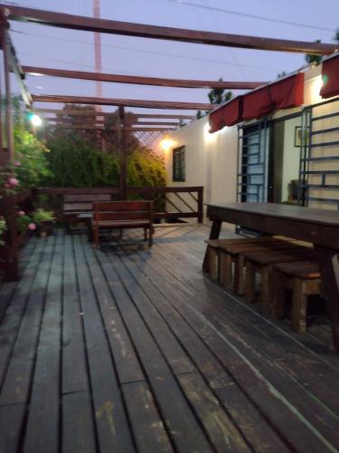 a wooden deck with benches and a building at Casa Módulo Bellavista in Bella Vista