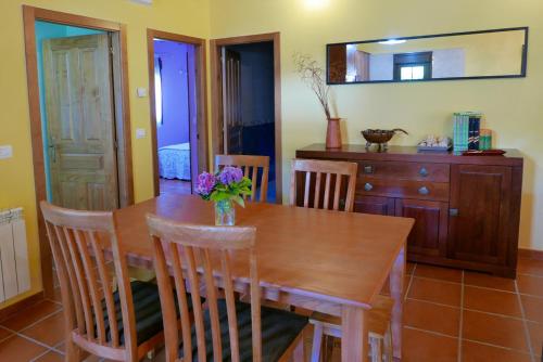 a dining room table with a vase of flowers on it at Casa de Aldea Playa de Arra in Collera