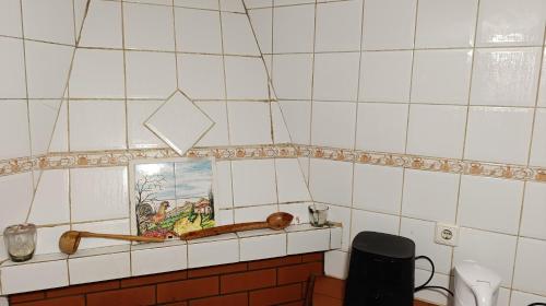 a tiled kitchen with a picture on a shelf at Orion Guesthouse Telhado in Fundão
