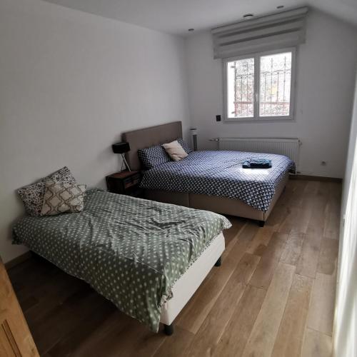 une chambre avec deux lits et une fenêtre dans l'établissement Maison entière 120 m2 Aix en Provence et grand jardin, à Aix-en-Provence