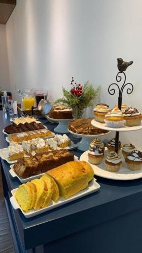 une table remplie de différents types de pâtisseries et de gâteaux dans l'établissement Pousada Villa Vie, à Gramado