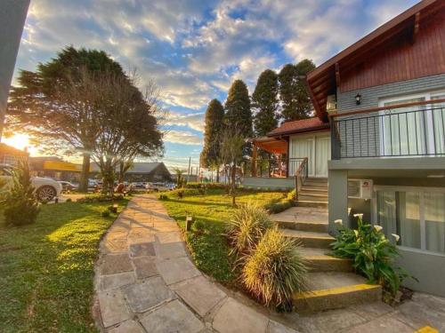 a house with a set of stairs leading to a yard at Pousada Villa Vie in Gramado