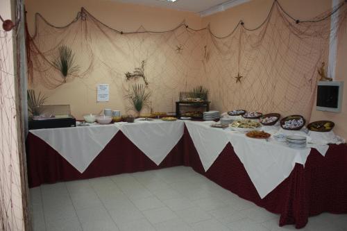 una mesa larga con comida encima en Hotel Castelsardo Domus Beach, en Castelsardo