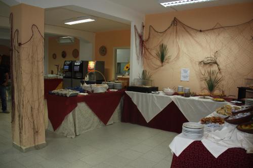 a buffet line with two tables with food on them at Hotel Castelsardo Domus Beach in Castelsardo