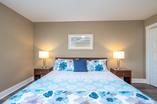 a bedroom with a bed with blue pillows and two lamps at Windsor Court - 12B in Spartanburg